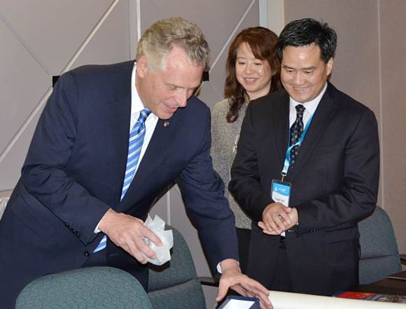 Mr. Terry McAuliffe is giving a gift to Mr. Frank Cao